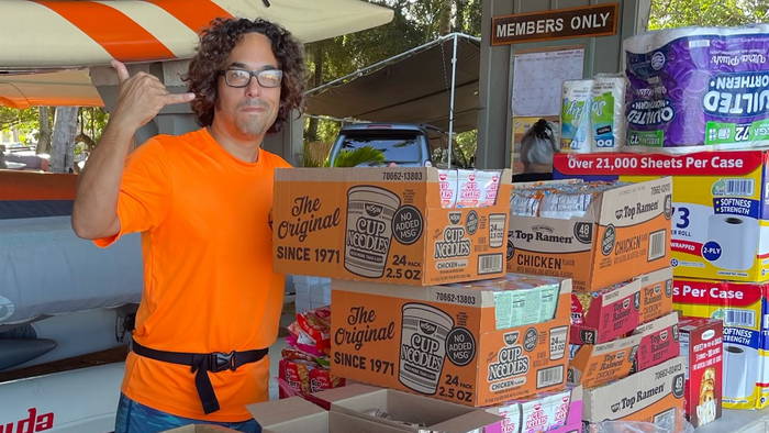 A volunteer poses next to donated food items.