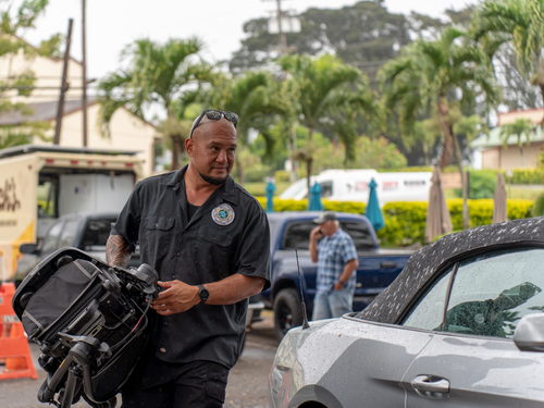 A KT Protection Services security professional carries a baby stroller to a clients car